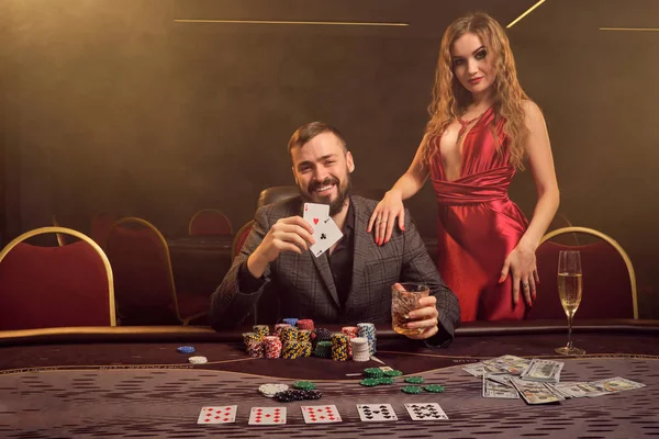 Okouzlující bohatý pár hrají poker v kasinu. — Stock fotografie
