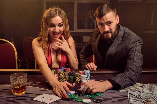 Encantadora pareja rica está jugando al póquer en un casino . — Foto de Stock