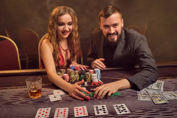 Encantadora pareja rica está jugando al póquer en un casino . — Foto de Stock