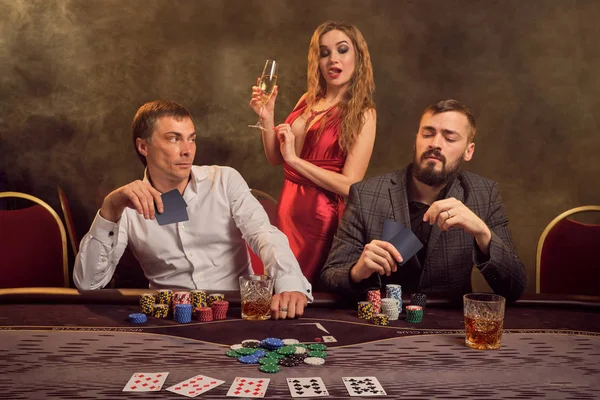 若い裕福な友人のグループがカジノでポーカーをしています。. — ストック写真