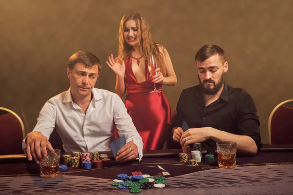 Grupo de jóvenes amigos ricos están jugando al póquer en un casino . — Foto de Stock