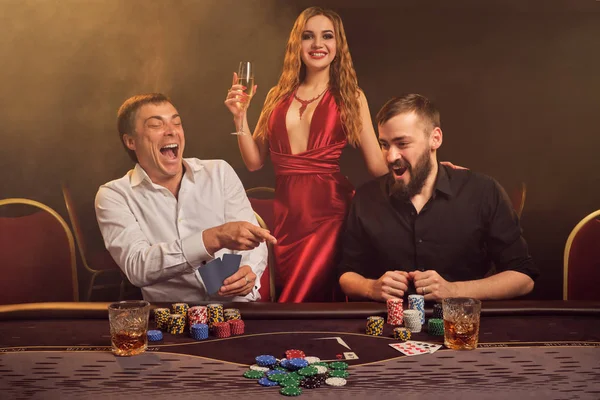 Grupo de jóvenes amigos ricos están jugando al póquer en un casino . — Foto de Stock