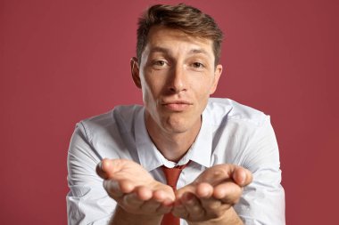 Kırmızı bir arka plana karşı bir stüdyoda poz genç bir Brunet adam portre.