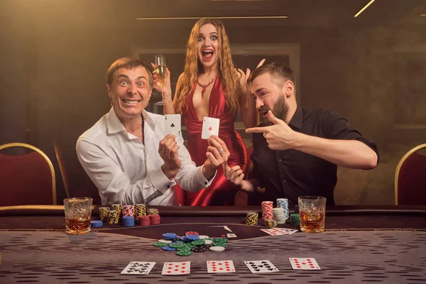 Grupp av unga rika vänner spelar poker på ett kasino. — Stockfoto