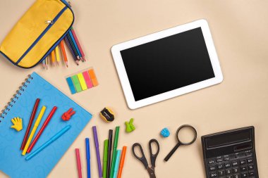 Çalışma masasının, okul aksesuarları ve ofis malzemeleriyle çekilmiş düz bir fotoğrafı..