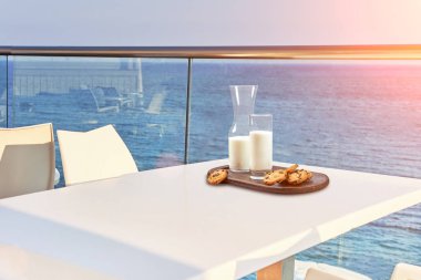 İki kişilik masa, açık hava otel balkonunda deniz manzaralı bir kahvaltıyla servis edilecek..