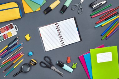 Çalışma masasının, okul aksesuarları ve ofis malzemeleriyle çekilmiş düz bir fotoğrafı..