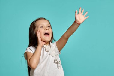 Mavi arka planda poz veren güzel esmer bir kızın yakın çekim stüdyosu..