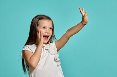 Mavi arka planda poz veren güzel esmer bir kızın yakın çekim stüdyosu..