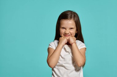 Mavi arka planda poz veren güzel esmer bir kızın yakın çekim stüdyosu..