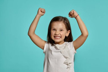 Mavi arka planda poz veren güzel esmer bir kızın yakın çekim stüdyosu..