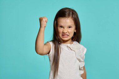 Mavi arka planda poz veren güzel esmer bir kızın yakın çekim stüdyosu..