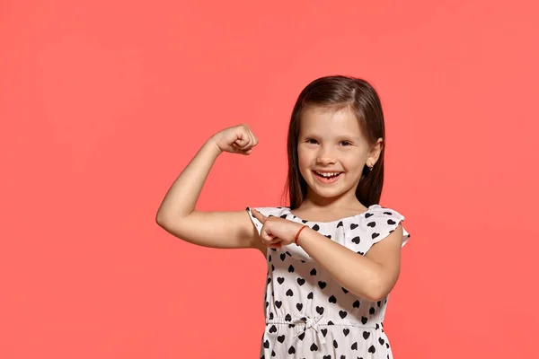 ピンクの背景に対してポーズ美しいブルネットの小さな女の子のクローズアップスタジオショット. — ストック写真