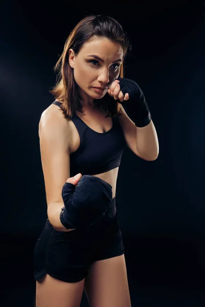 Спортивная женщина в боксёрских рукавицах занимается карате в студии . — стоковое фото
