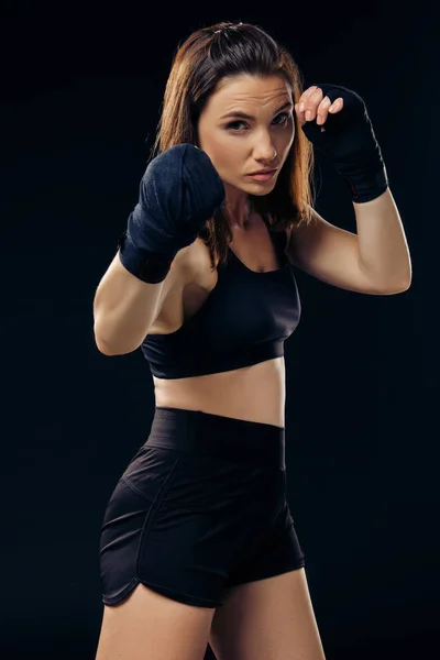 Спортивная женщина в боксёрских рукавицах занимается карате в студии . — стоковое фото
