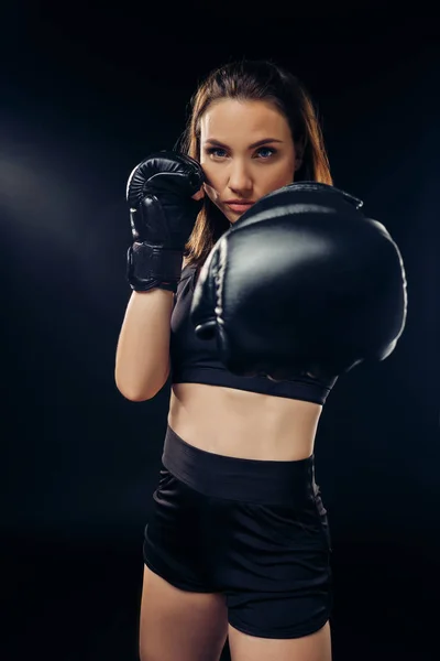 Mujer atlética en guantes de boxeo está practicando karate en estudio . — Foto de Stock