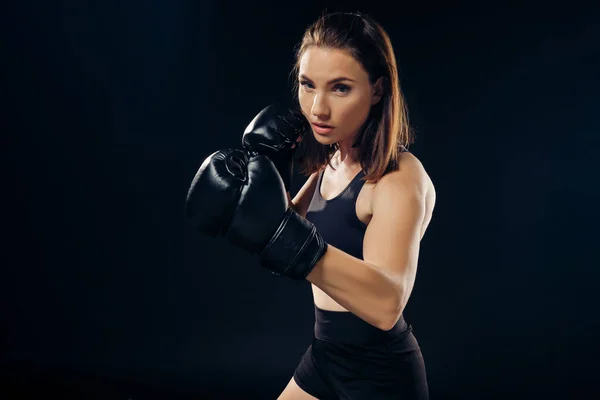 Athletische Frau mit Boxhandschuhen übt Karate im Studio. — Stockfoto