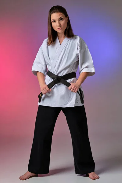 Athletic woman in traditional kimono is practicing karate in studio. — Stock Photo, Image