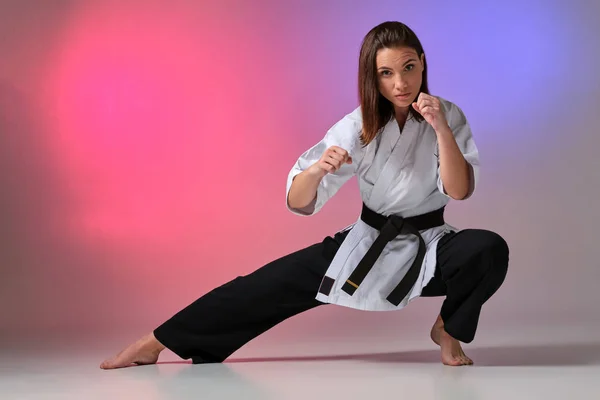 Donna atletica in kimono tradizionale sta praticando karate in studio . — Foto Stock