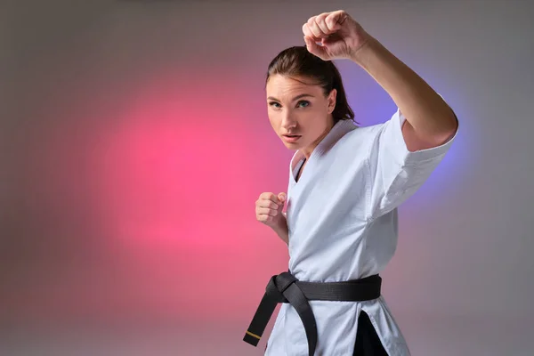 Atletische vrouw in traditionele kimono is het beoefenen van karate in Studio. — Stockfoto
