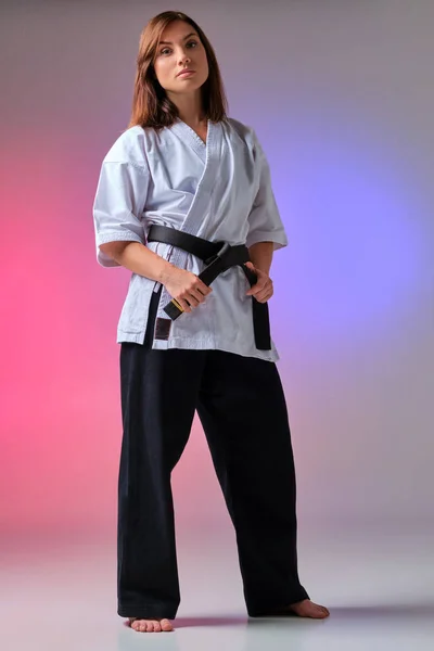 Atletická žena v tradičním kimonu trénuje karate ve studiu. — Stock fotografie