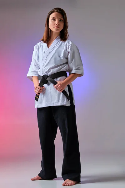 Athletische Frau im traditionellen Kimono übt Karate im Studio. — Stockfoto