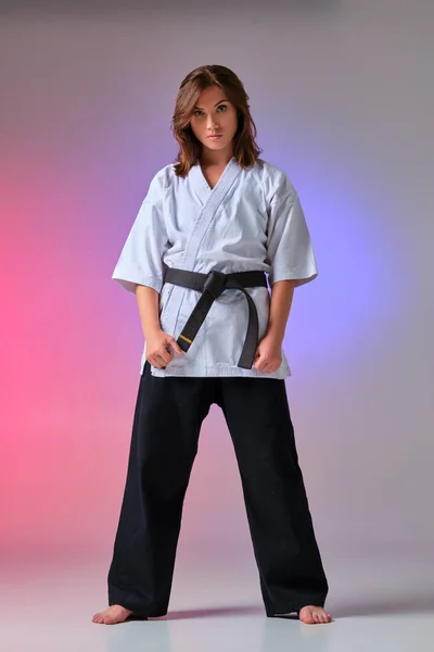 Athletische Frau im traditionellen Kimono übt Karate im Studio. — Stockfoto