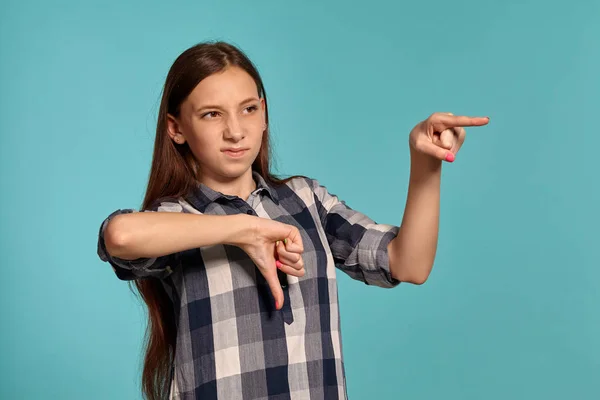 캐주얼 체크 무늬 셔츠에 아름다운 십대 소녀는 파란색 스튜디오 배경에 대해 포즈를 취하고있다. — 스톡 사진
