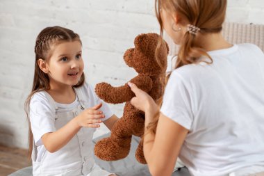 Yatak odası iç karşı poz onu sevimli küçük kızı ile güzel bir annenin Kapalı portre.