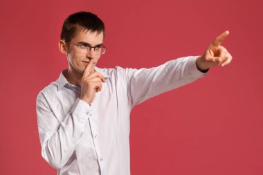 Klasik beyaz gömlekli genç adam pembe arka planda poz veriyor..