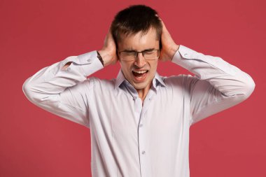 Klasik beyaz gömlekli genç adam pembe arka planda poz veriyor..