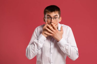 Klasik beyaz gömlekli genç adam pembe arka planda poz veriyor..