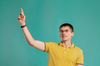 Sarı rahat t-shirt yakışıklı adam mavi bir arka plan üzerinde poz.