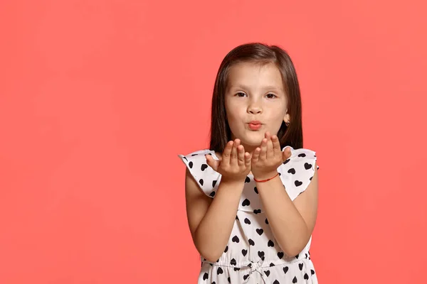 ピンクの背景に対してポーズ美しいブルネットの小さな女の子のクローズアップスタジオショット. — ストック写真