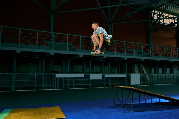 The man performs a trick. Jump. Indoor training — Stock Photo, Image