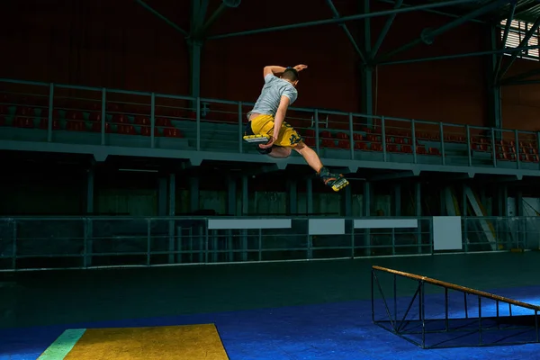 Mannen utför ett trick. Hoppa. Inomhusträning — Stockfoto