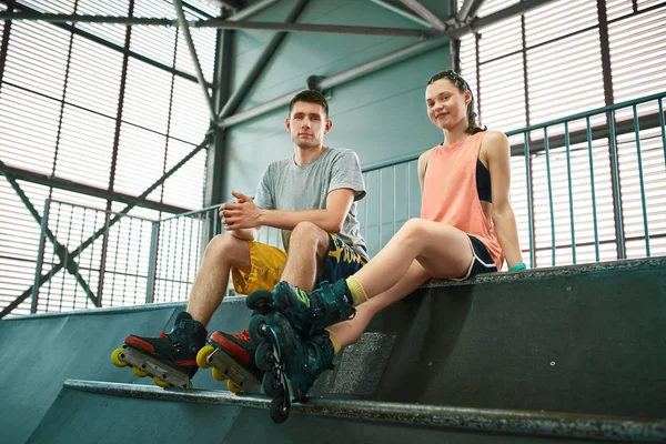 Молодий чоловік і жінка розважаються на роликових ковзанах в ковзанах парку. Хобі — стокове фото