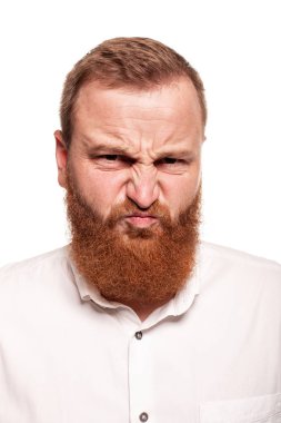 Beyaz bir arka plan üzerinde izole, kamera yüzleri yapma beyaz gömlek li genç, tombul, kızıl saçlı bir adamın portresi