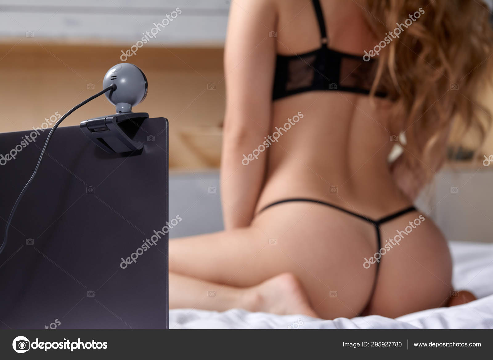 Beautiful, young girl posing in front of a web camera, working as a model. He takes off his