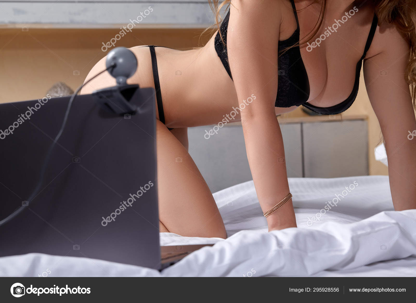 Beautiful, young girl posing in front of a web camera, working as a model. He takes off his