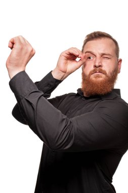 Beyaz bir arka plan üzerinde izole, kamera yüzleri yapma siyah gömlekli genç, tombul, kızıl saçlı bir adamın portresi