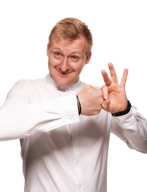 Heybetli, beyaz gömlekli genç, sarışın adam beyaz bir arka plan üzerinde izole dururken grimacing olduğunu
