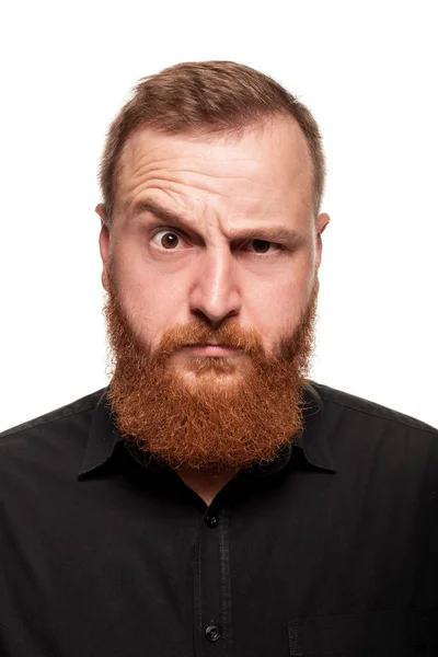 Portrait d'un jeune homme roux, potelé, vêtu d'une chemise noire faisant des grimaces à la caméra, isolé sur fond blanc — Photo