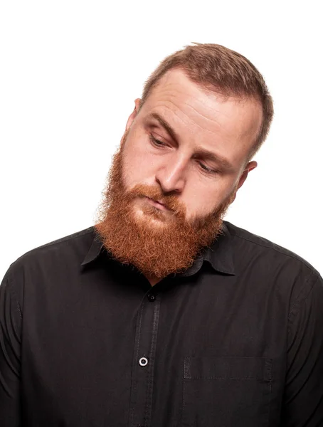 Portrait of a young, chubby, redheaded man in a black shirt making faces at the camera, isolated on a white background — Stock Photo, Image