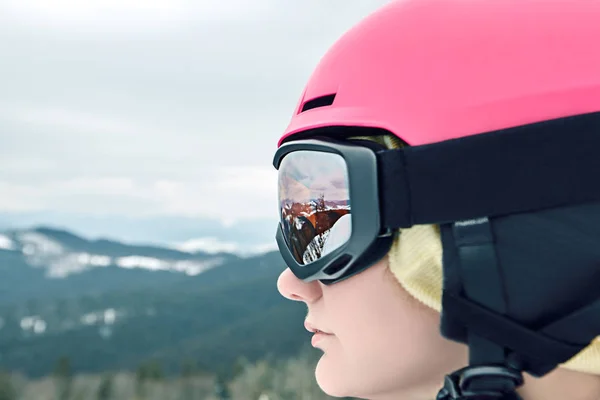 滑雪胜地滑雪场滑雪者戴着头盔和护目镜，反映山脉的特写肖像. — 图库照片