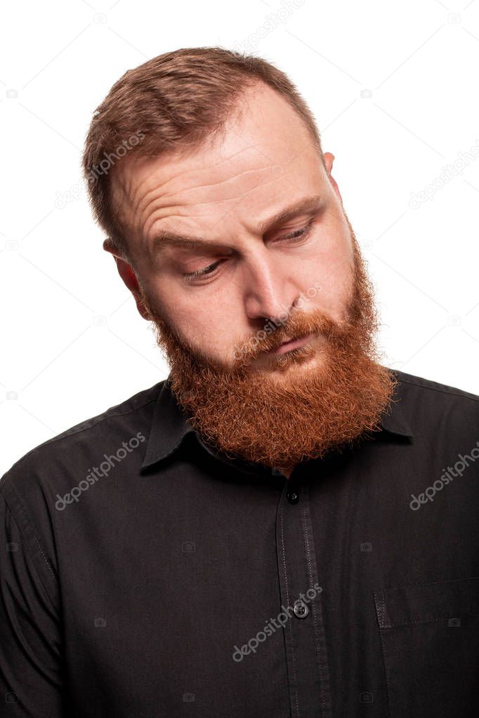 Portrait of a young, chubby, redheaded man in a black shirt making faces at the camera, isolated on a white background