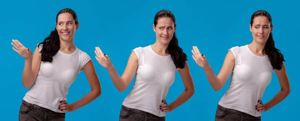 Schöne Frau in einem weißen lässigen T-Shirt posiert vor blauem Studiohintergrund. — Stockfoto