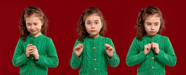 Porträt eines schönen kleinen Mädchens in grünem Strickpullover, das auf rotem Hintergrund posiert. — Stockfoto