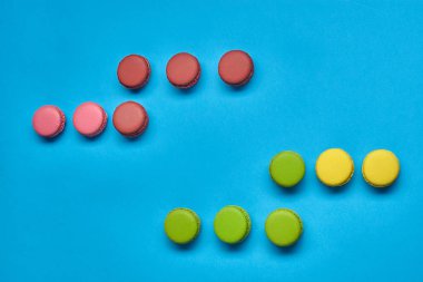 Renkli badem kurabiyesi ya da badem kurabiyesi, mavi arka planda tatlı kremalı şekerleme. Yakın plan, kopyalama alanı.