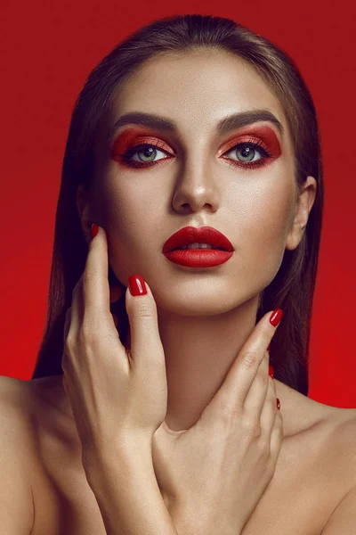 Potret glamor close-up dari model setengah telanjang yang indah dengan pose riasan cerah di atas latar belakang merah. — Stok Foto